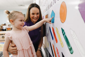 A Tierra Encantada teacher and a child in a classroom.